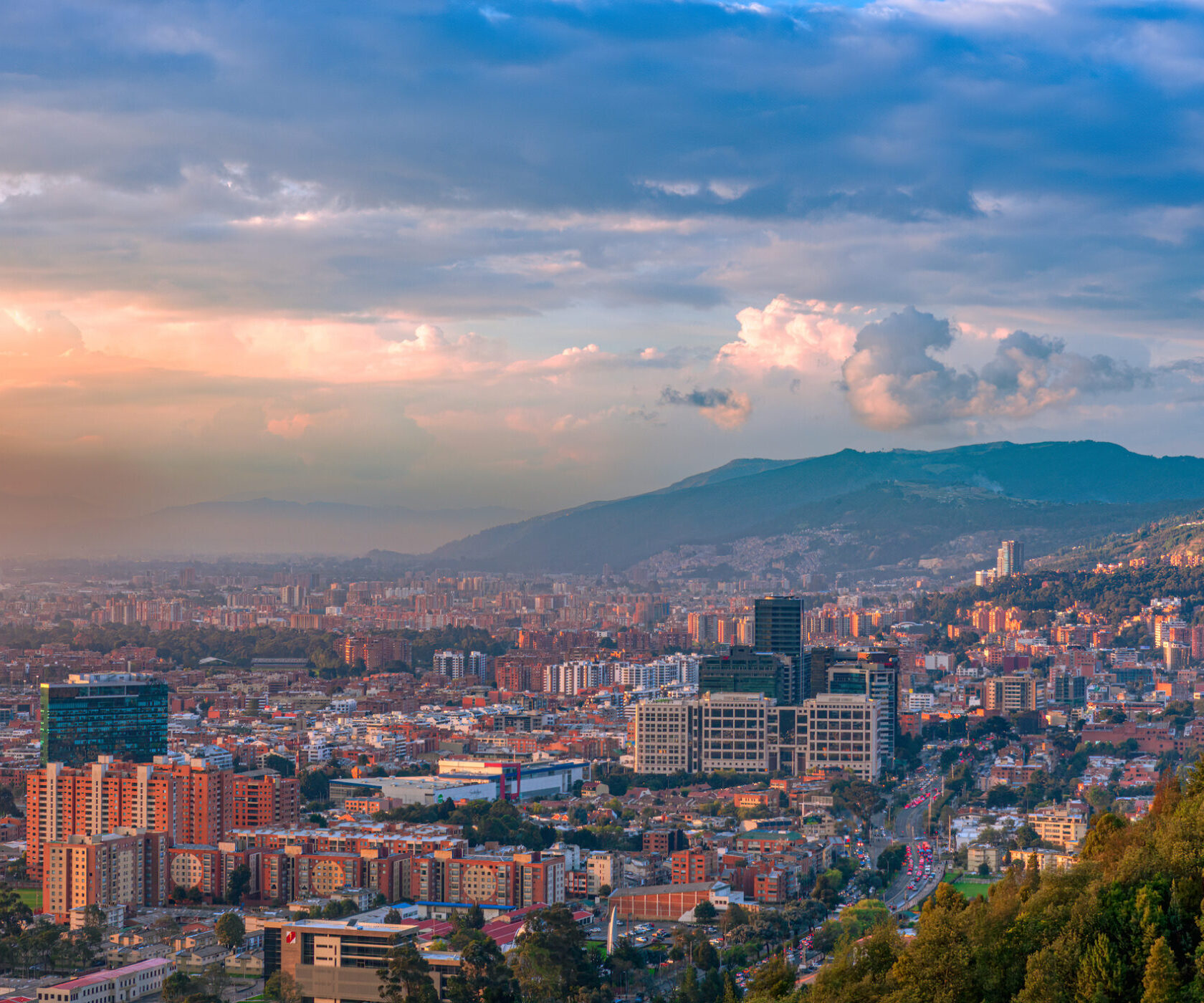 Bogota Colombia - It is sunset time in the Northern part of the Capital city and District of Usaquén in Bogotá, Colombia, South America as viewed from the heights of La Calera on the Andes Mountains. The city at street level is located at an altitude of 8,660 feet above mean sea level. Downtown Usaquén with its modern office buildings can be clearly seen. Horizontal format; copy space.